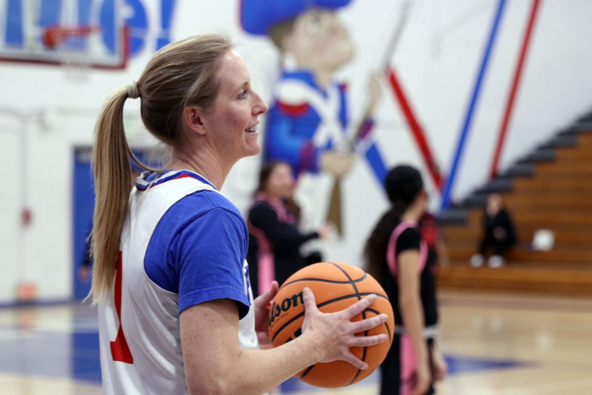 Baller! During the staff vs. varsity basketball fundraiser, Assistant Principal Tessa Riley looks for an open player. The staff defeated the girls' varsity team by two points. 