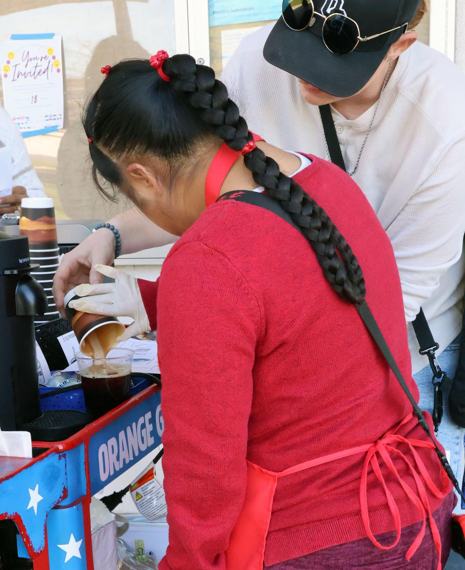 MMMM, aid Mo Fegan is helping Destiny  Carrillo, 11 finish up a coffee that she can deliver. Photo By Sofi Melchor