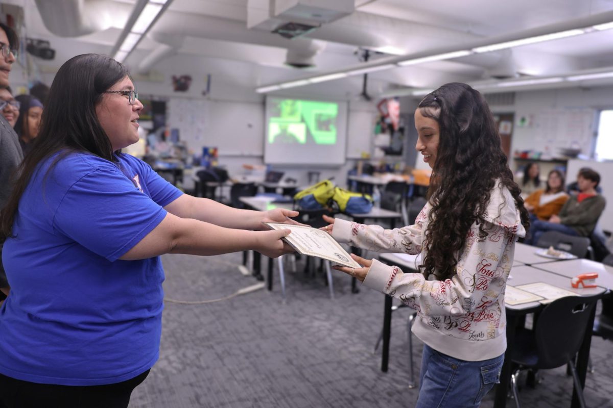 Season well spent! With the NCAL season closing Advisor Tia D'Saro hands out a recognition awards to student Kassandra Yanez, 12, to celebrate the growth she's accomplished throughout the season.