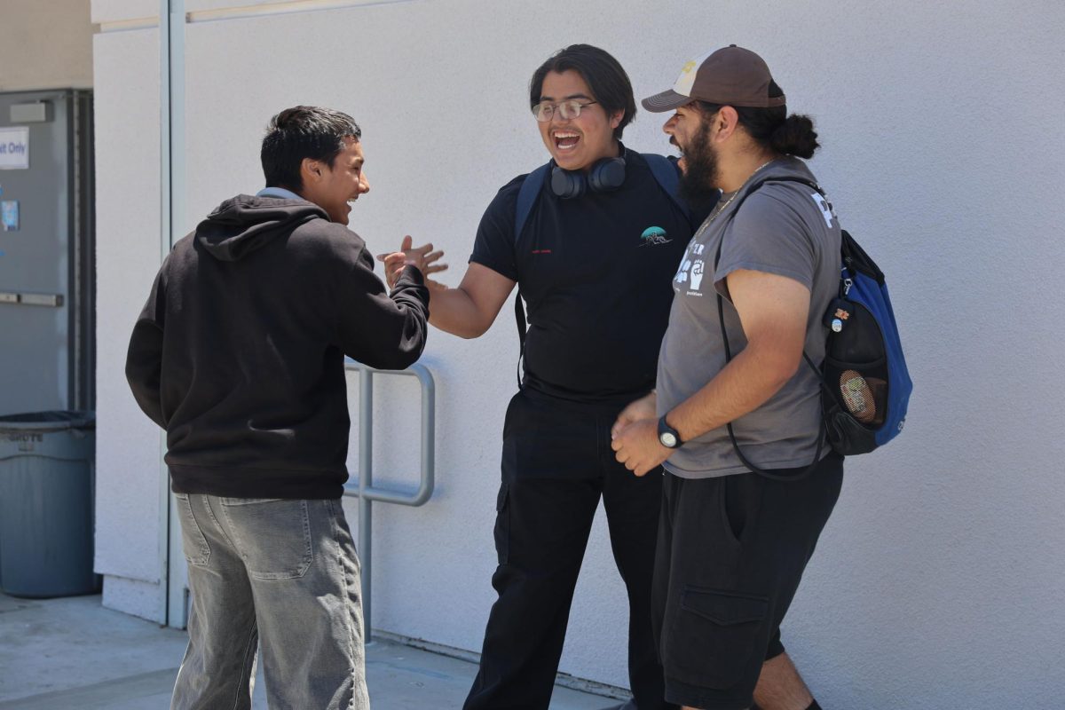 Sinking shots, saving cash. Joel Peña, 12th grade, shares a moment of celebration with students Emilio Aguilar, 12, and Yurem Novoa, 12, after winning a cup pong game and earning back money for prom at ASB lunch game.