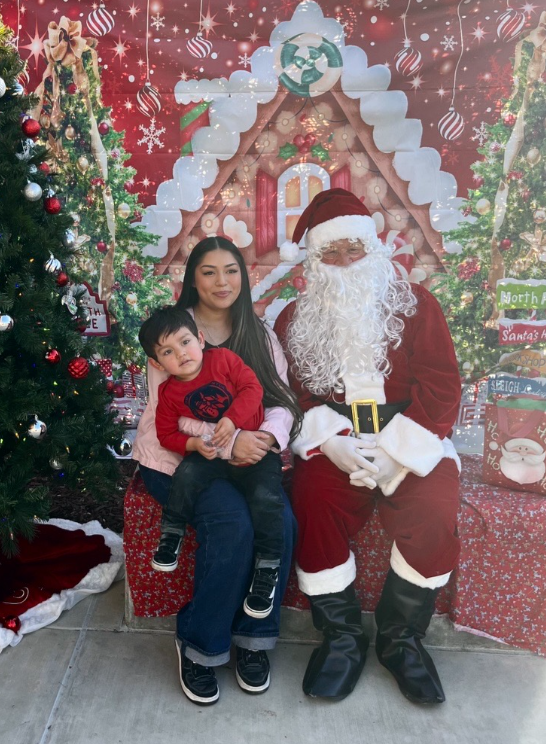 Taking a picture with Santa, Amy Martinez, 12, and her son at the Cal-Safe annual Christmas party.