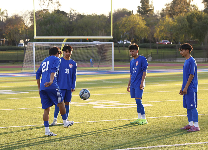 Pass around. Juggling a soccer ball, Soccer player Luis Martinez, 11, practices with his teammates on balancing a soccer ball. Martin Ibarra, 11, Juan Lopez, 11, Marco Sarabia, 11, and Martinez discuss how they will travel across the field as they practice their balancing skills. “I look forward to using my teammates as an advantage to travel and make that shot,” Sarabia said. Martinez has played on the Soccer team for three years, and was selected as Team Captain as a junior. Photo by Richie Martinez