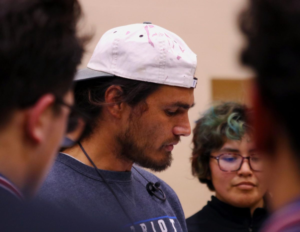 Matchups secured. With the wrestlers curious for the finalized lineup, Assistant Coach Tyler Muehlhauser gathers his team and goes over each matchup before they take the mat at their home dual meet. Quetzale Mendoza listens along with the rest of the team for their match against Sage Creek High School. “Stay in the fight, its okay to be strong,” Tyler Muehlhauser said. Aside from coaching the wrestling team as a side job, Muehlhauser is a jack-of-all-trades when it comes to his line of work, some would call him a troubleshooter. Photo by David Villeda