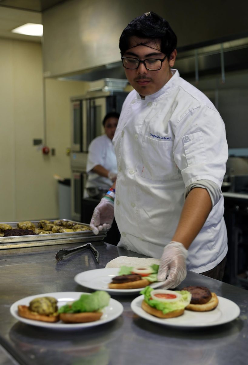 Gloves on. Working on his last patriot cafe, Alen Salgado, 12, was working fast and getting food out as quickly as possible. "I was working the back helping direct orders, it was fun but a little stressful," Salgado said. Salgado has been in culinary for 4 years and has worked many patriot cafe.